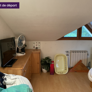 Mur sous-pente avec commode, ventilateur et télévision dans une chambre avant rénovation