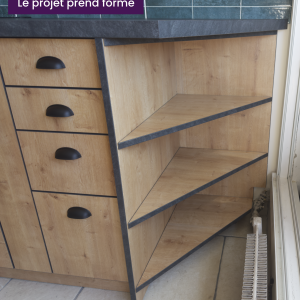 Zoom sur le meuble d’angle ouvert avec étagères triangulaires – finitions en bois clair et chants sombres
