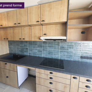 Vue rapprochée du plan de travail noir avec évier encastré et plaques de cuisson – cuisine sur mesure à Villeurbanne